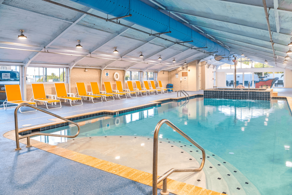 a large indoor swimming pool with yellow chairs