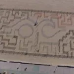 an aerial view of a maze on the beach